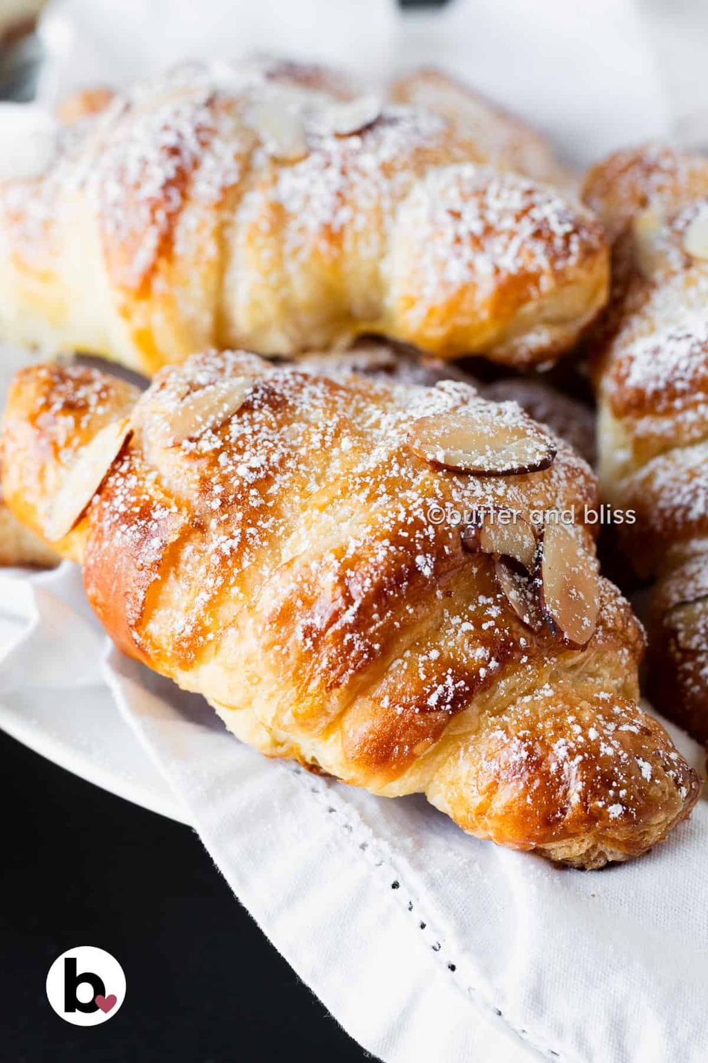 Almond croissant topped with flaked almonds and icing sugar